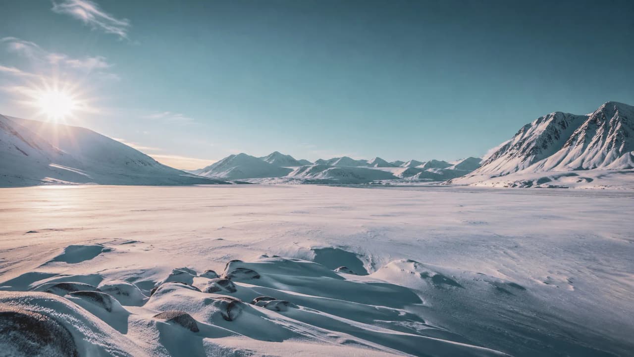 Een besneeuwd landschap in Noors Lapland, met majestueuze bergen onder een stralend blauwe hemel.