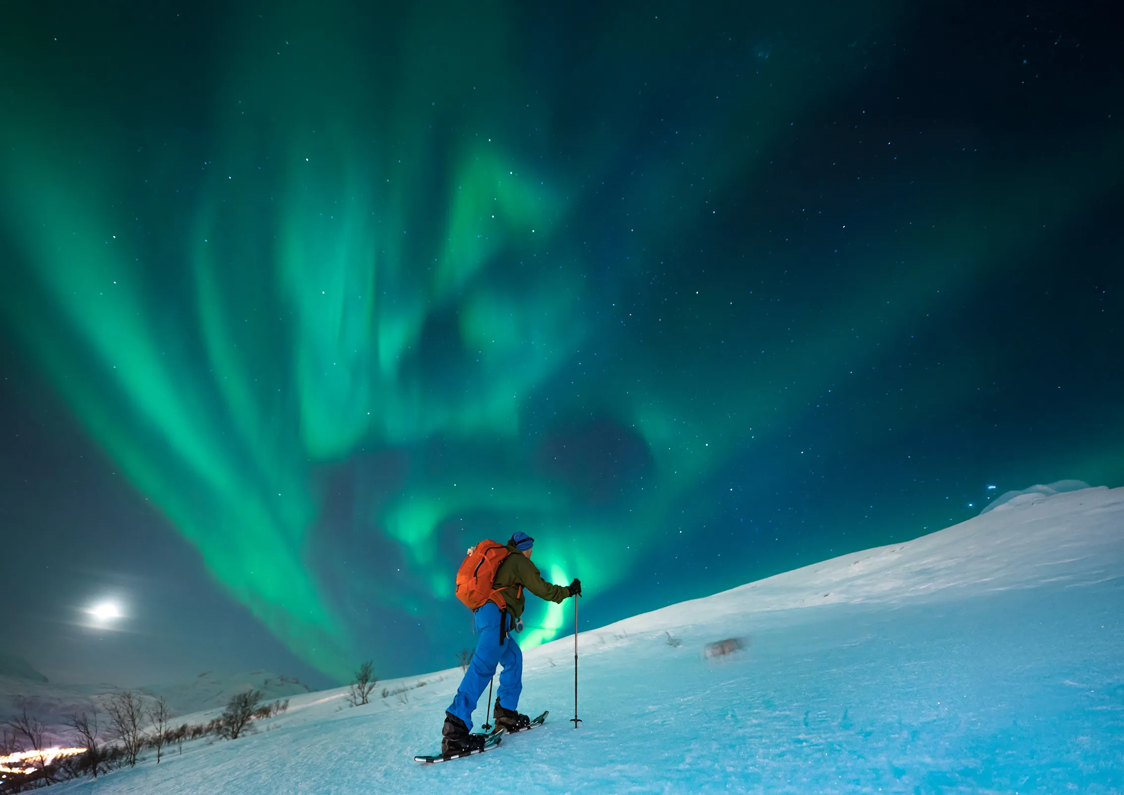 Adventuring on snowshoes under the northern lights on the island of Senja, Norway.