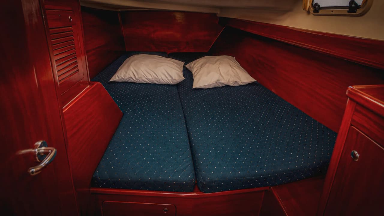 Gezellige hut op een zeilboot, met comfortabele matrassen en kussens, een uitnodiging om te ontsnappen naar zee.