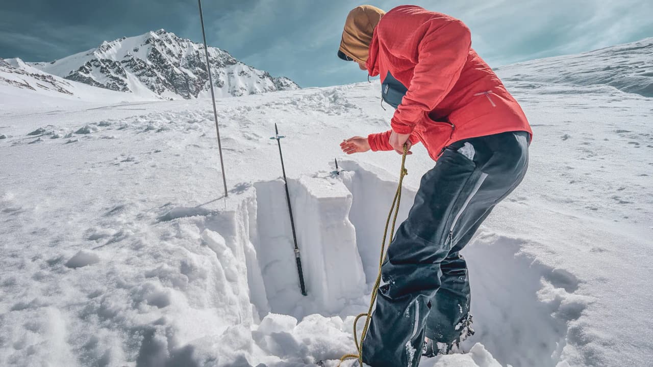 Winter exploration around Mont Blanc: skier inspecting a hole in the glistening snow.