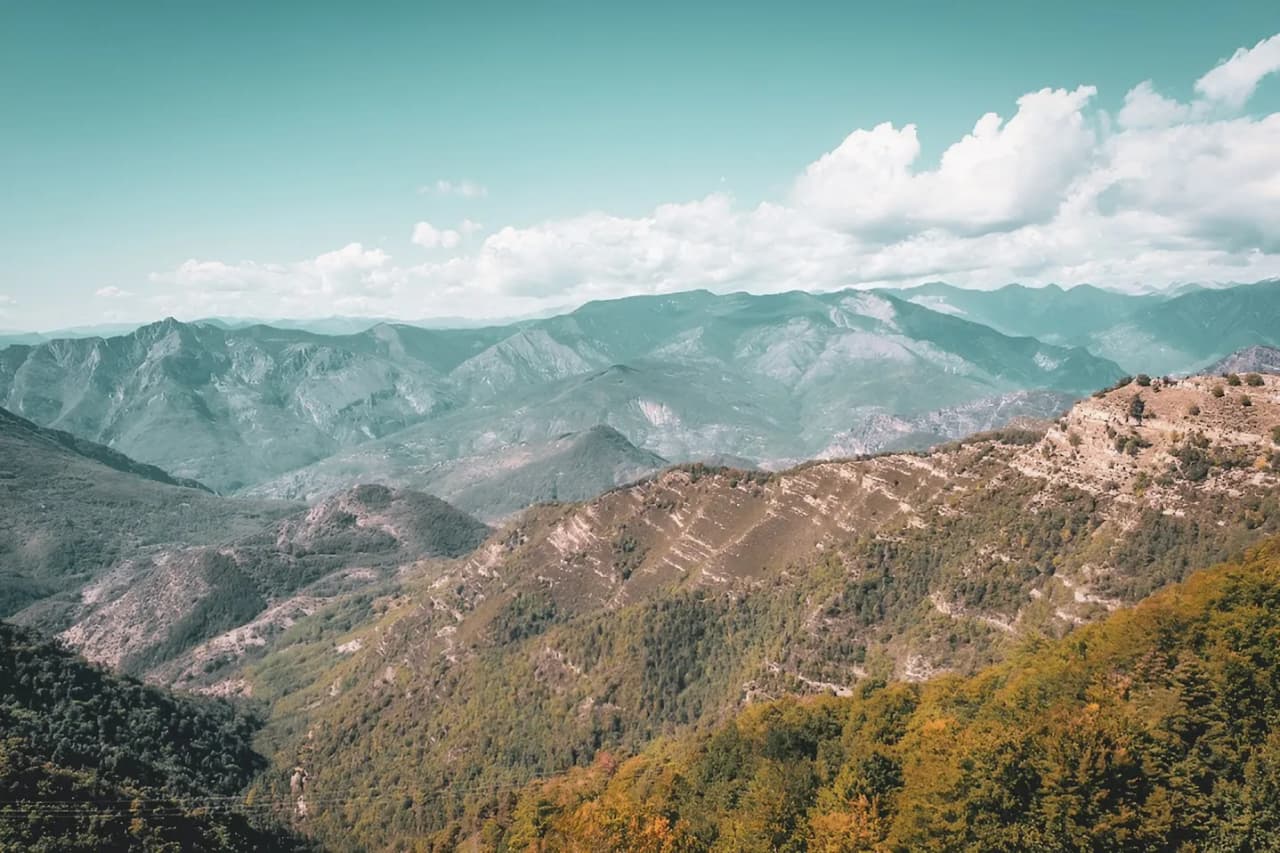 Panorama majestueux des montagnes du Mercantour, entre forêts verdoyantes et céniques vallées.