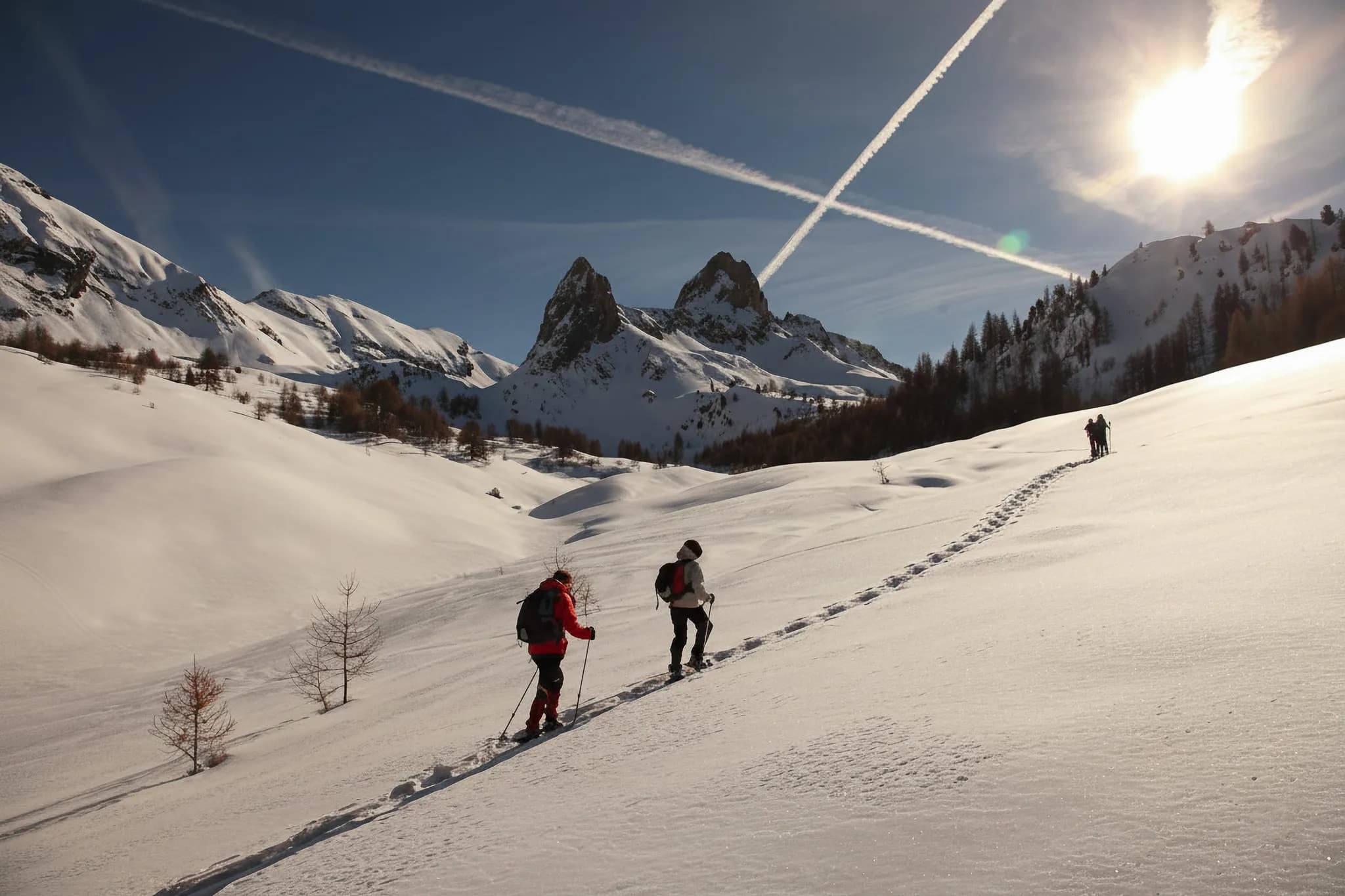 Randonnée en raquettes sur un panorama enneigé, sous un ciel bleu éclatant et le soleil radieux.