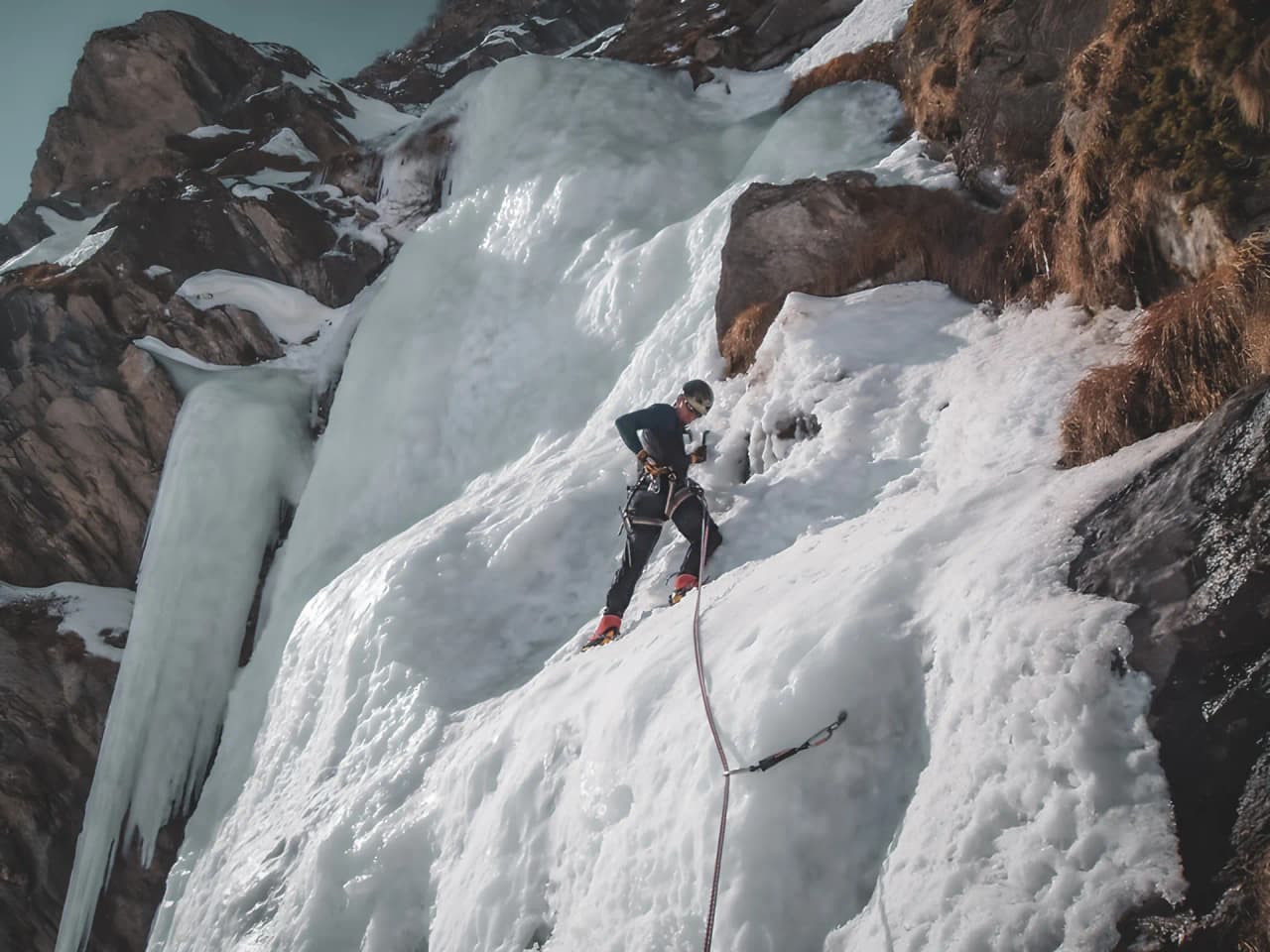 Un alpiniste s'aventure sur une cascade de glace dans les Alpes italiennes.