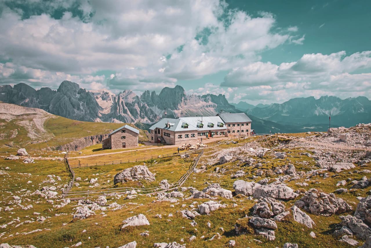Mountain hut surrounded by impressive peaks, an invitation to adventure in the Dolomites.