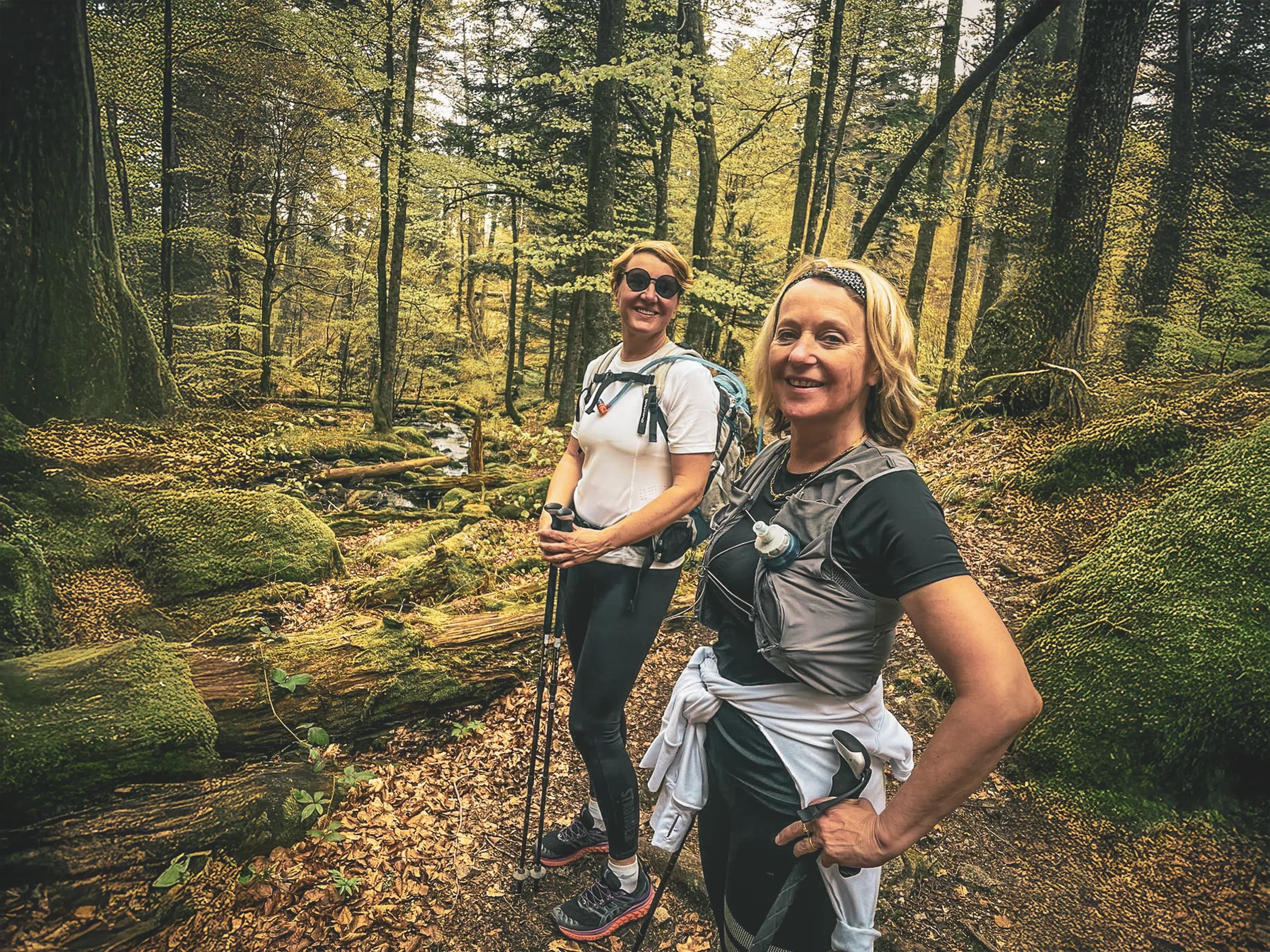 Two smiling women in the middle of nature, ready for a trail course in the Vosges.