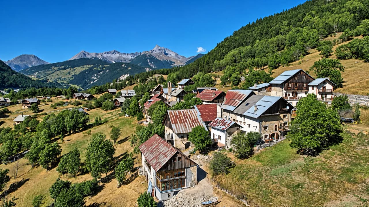 Een pittoresk dorpje in het Queyras-gebergte, met groene landschappen en majestueuze bergtoppen.