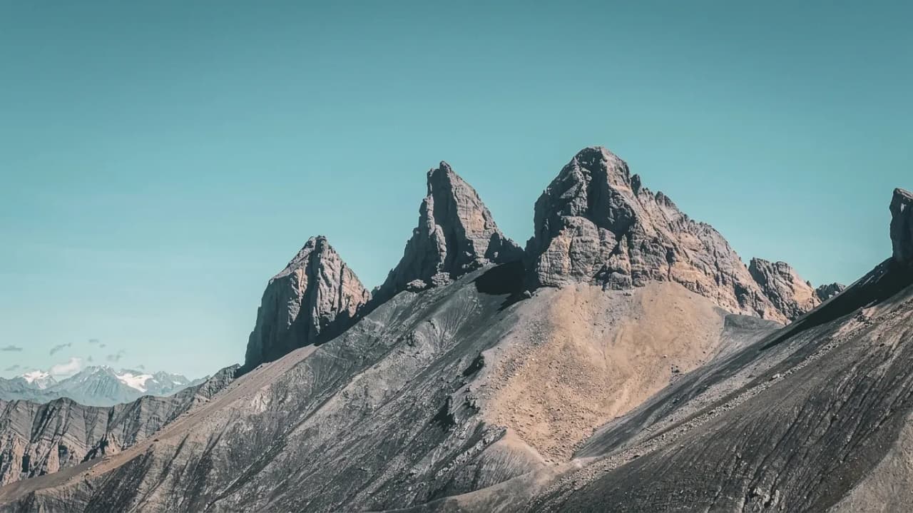 Montagnes majestueuses aux arêtes défiant le ciel, invitation à l'aventure alpine.