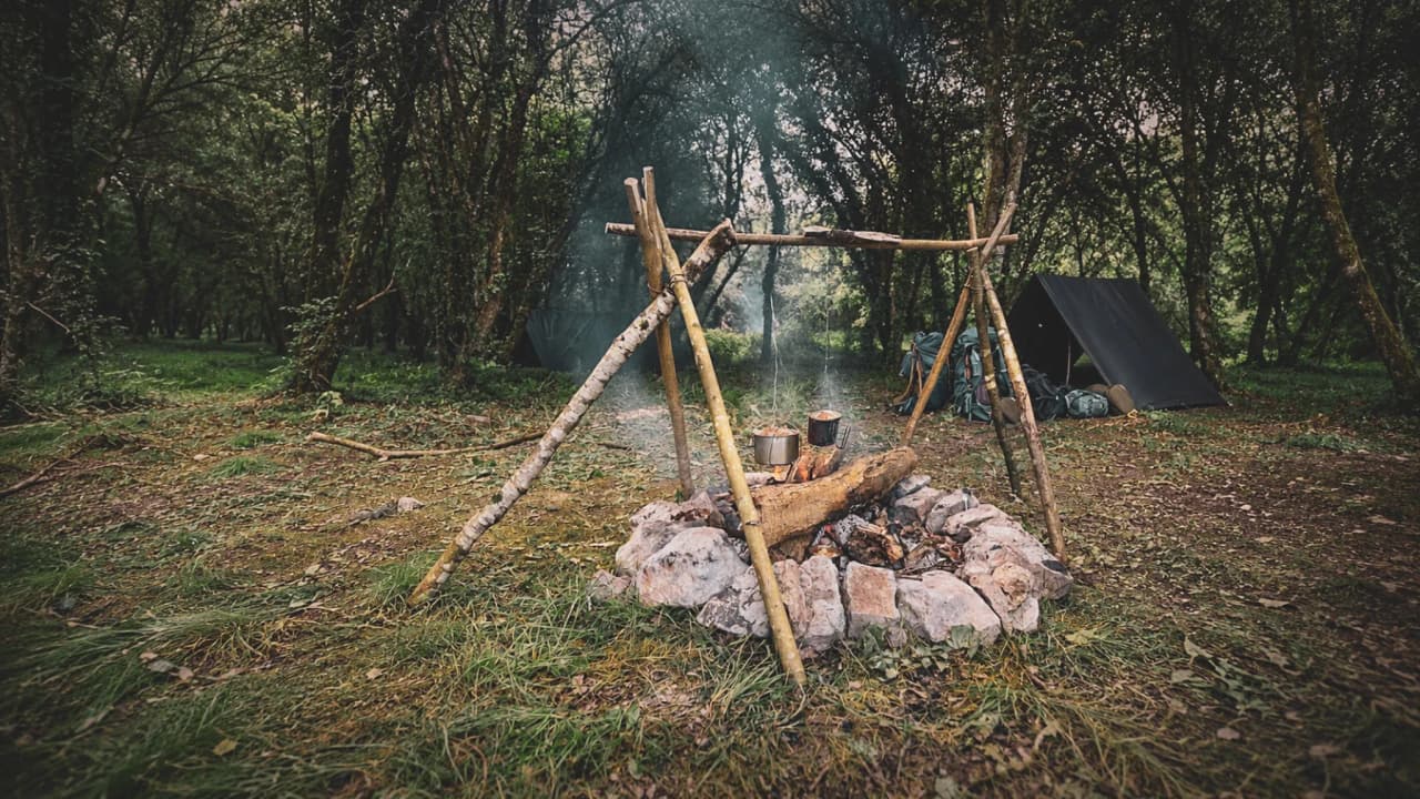 Un feu de camp réchauffe la forêt ardennaise, invitant à l'aventure en pleine nature.