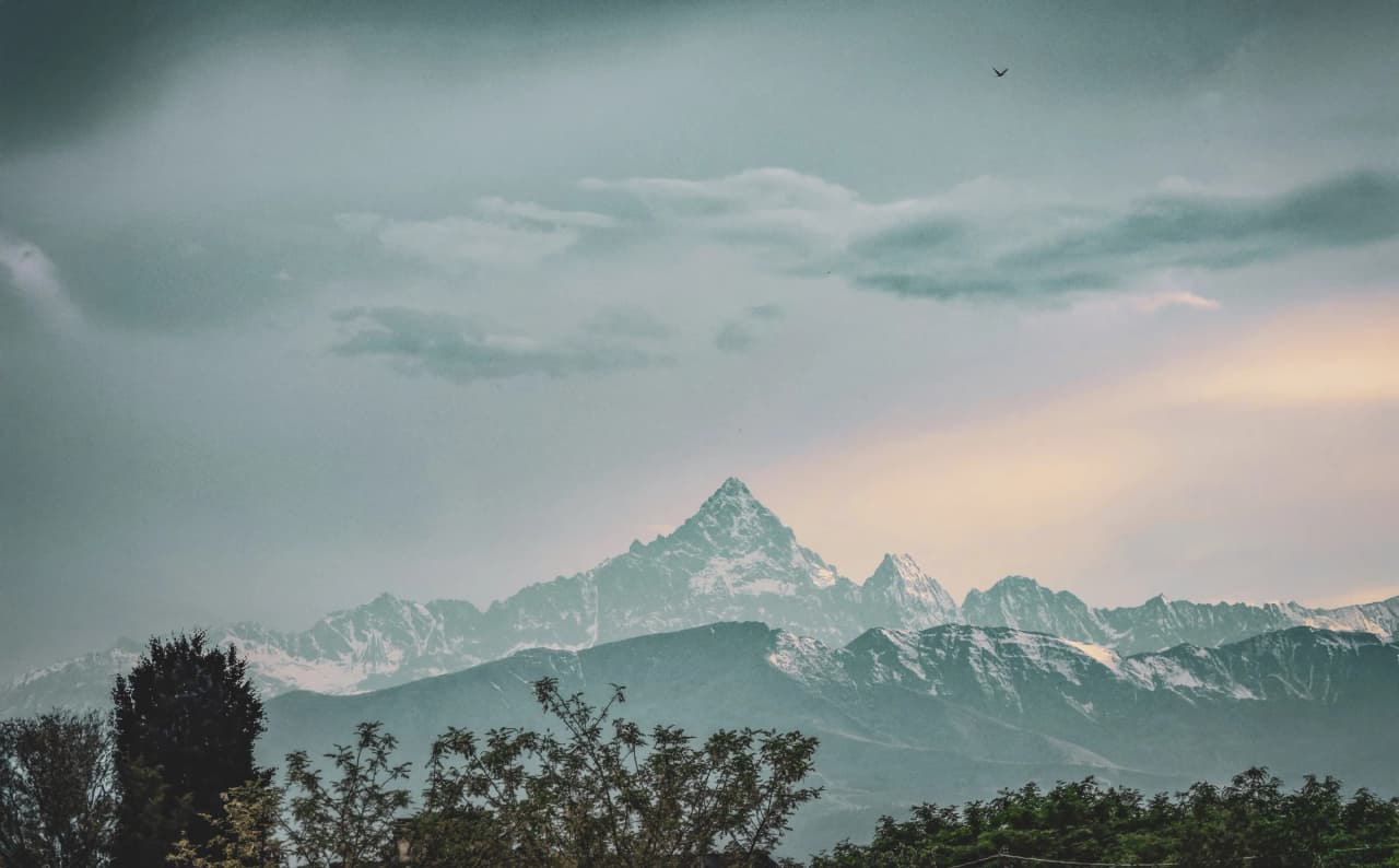 Mont Viso majestueux, illuminé par un ciel nuageux, invite à l'aventure en randonnée.
