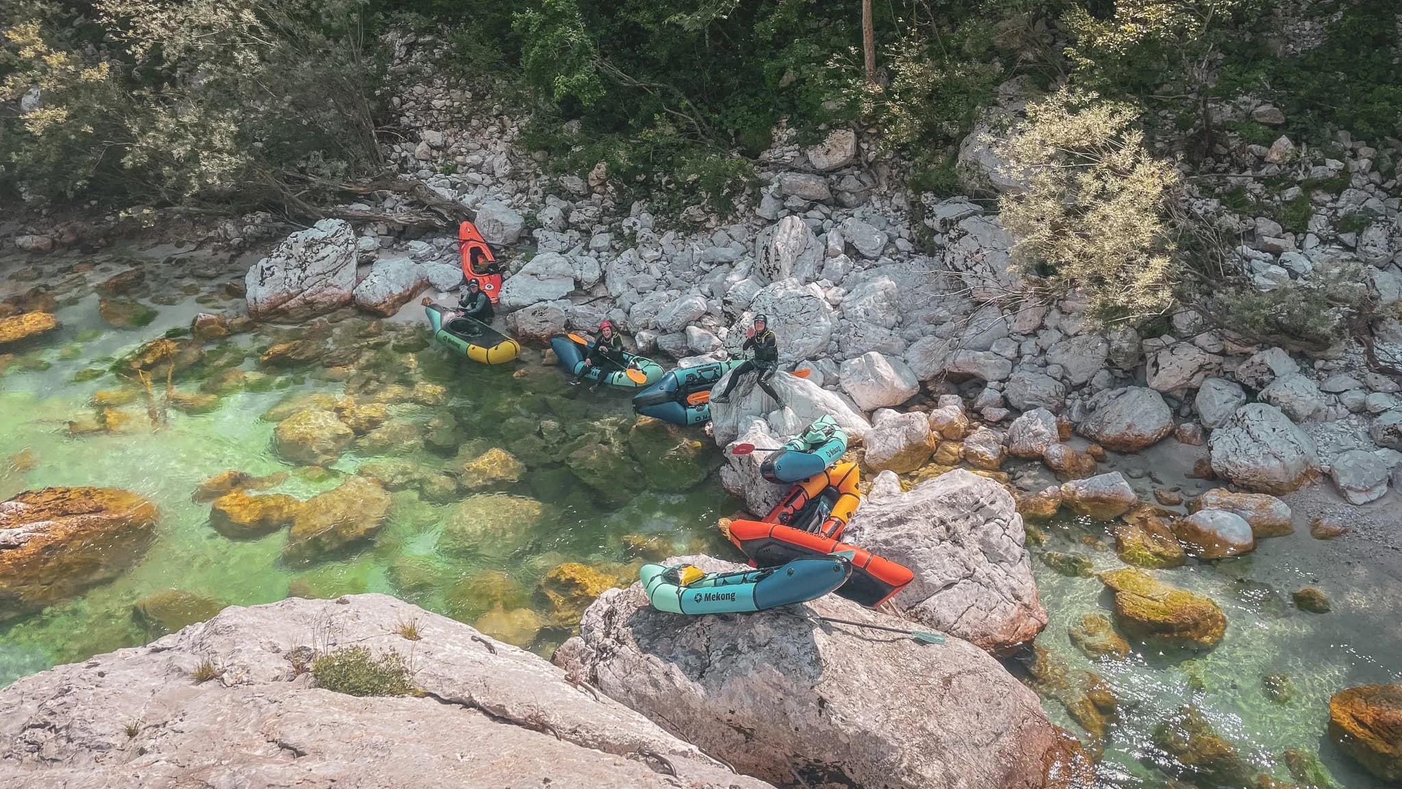 Un groupe de packrafteurs sur des rivières cristallines, entourés de magnifiques paysages rocheux.