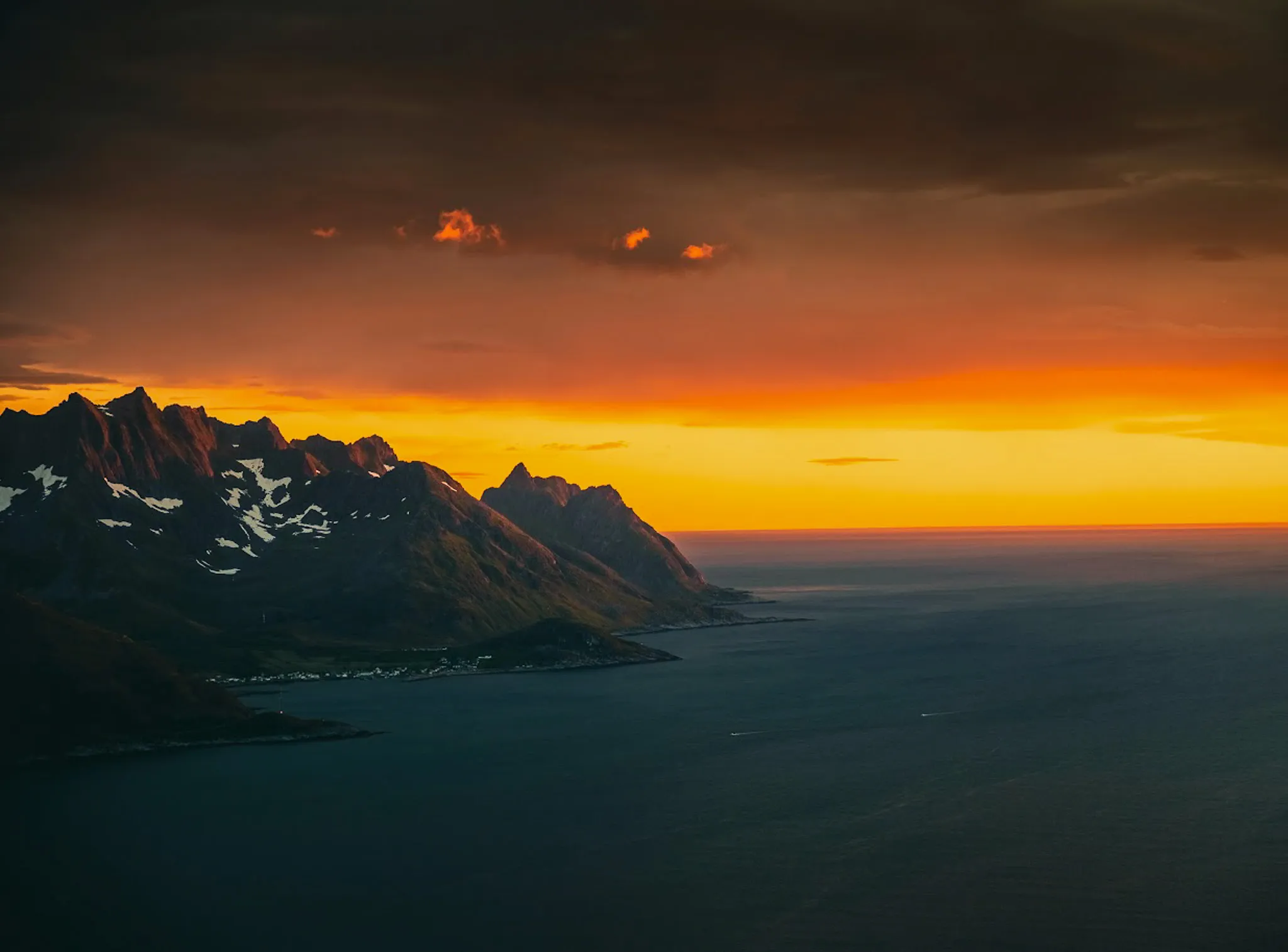 Magnificent scenery on the island of Senja, where majestic mountains meet a blazing sunset.