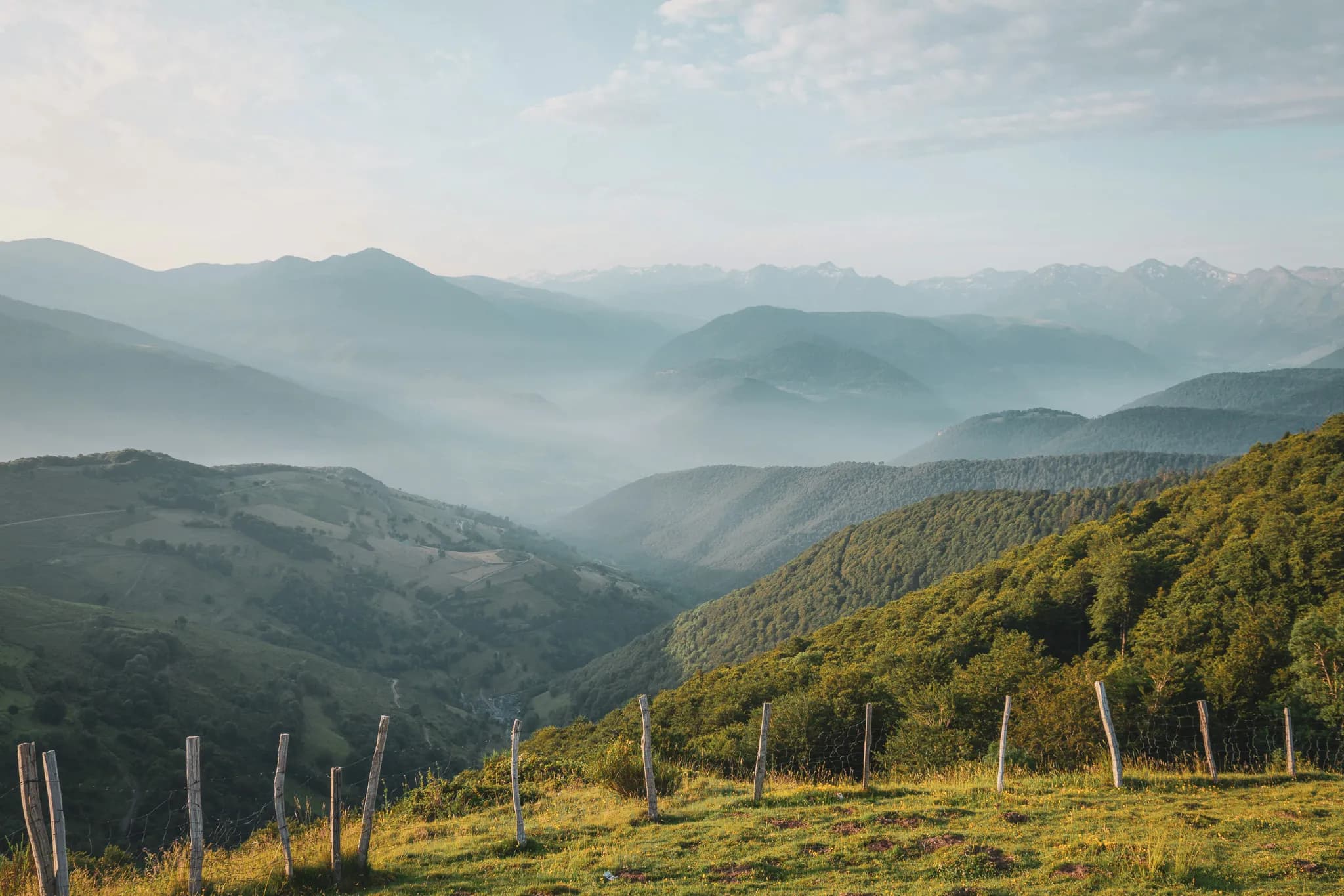 Vastes montagnes verdoyantes baignées de lumière, invitant à l’évasion et à l’aventure.