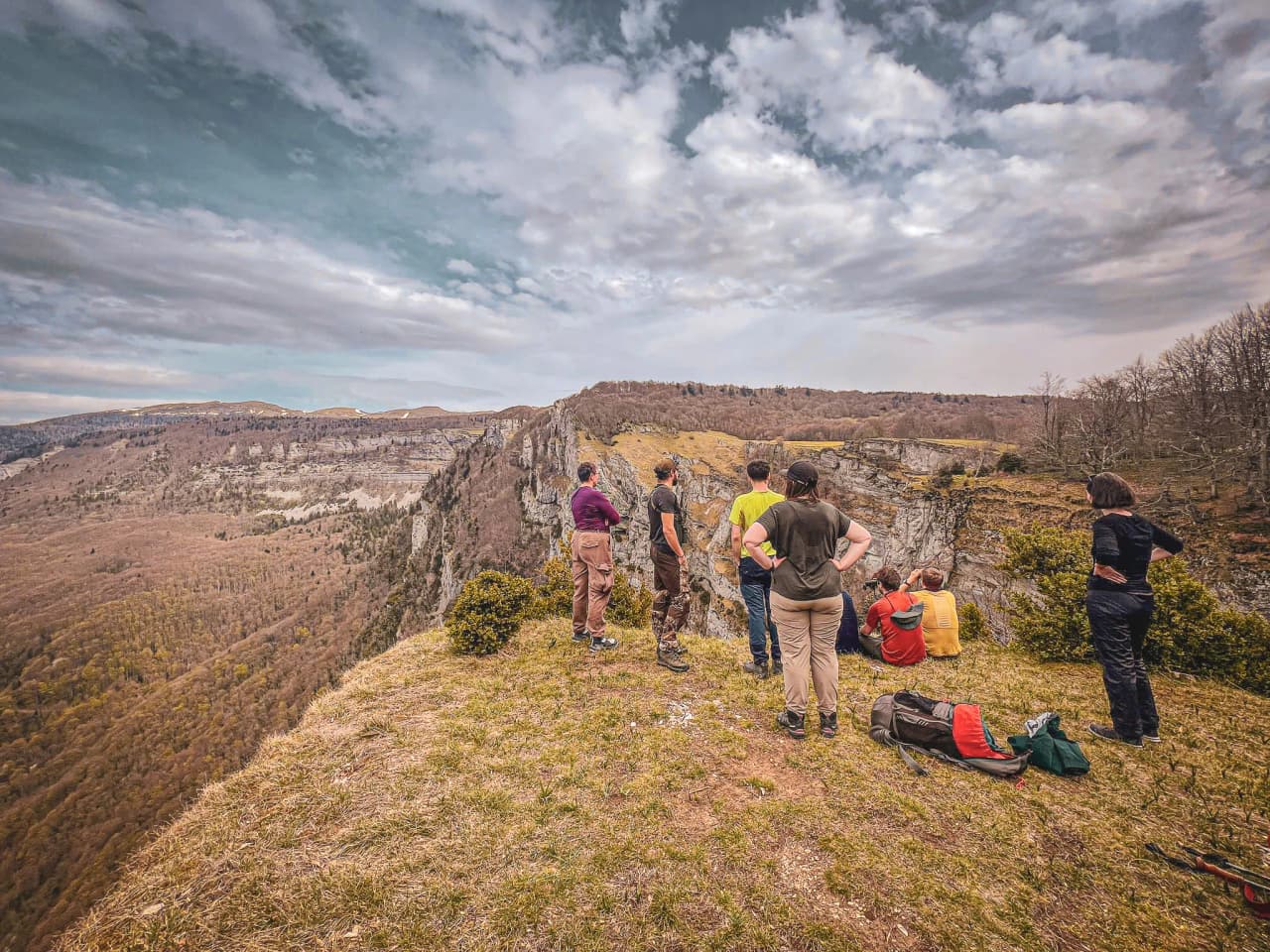 Een groep wandelaars bekijkt een panorama van kliffen en valleien, een meeslepende scène van buitenverkenning en spectaculaire natuurlijke landschappen.