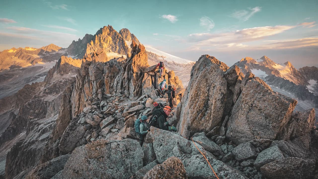 Alpinistes gravissant des rochers au sommet pittoresque, avec des vues spectaculaires sur les montagnes.