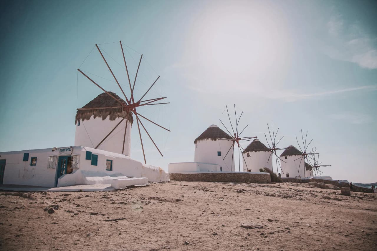 Moulins emblématiques sous un ciel bleu, invitation à explorer les Cyclades.