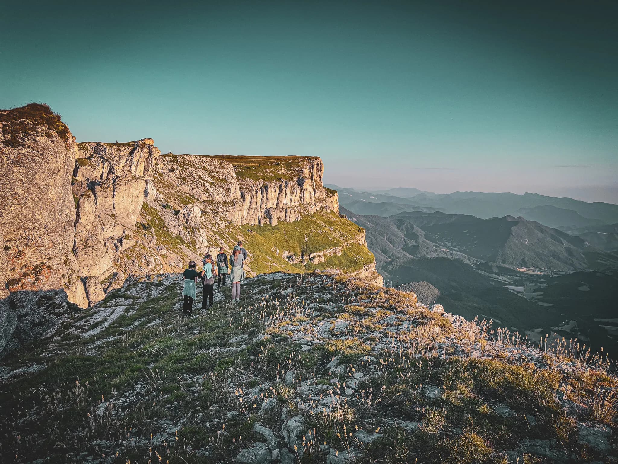 A group of explorers on a spectacular mountain landscape in the Vercors, under a clear sky.