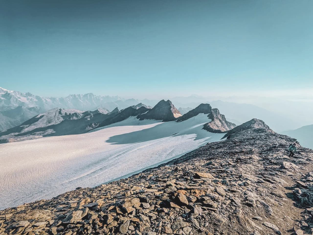 Vue imprenable sur des sommets majestueux et un glacier étincelant sous le ciel bleu.