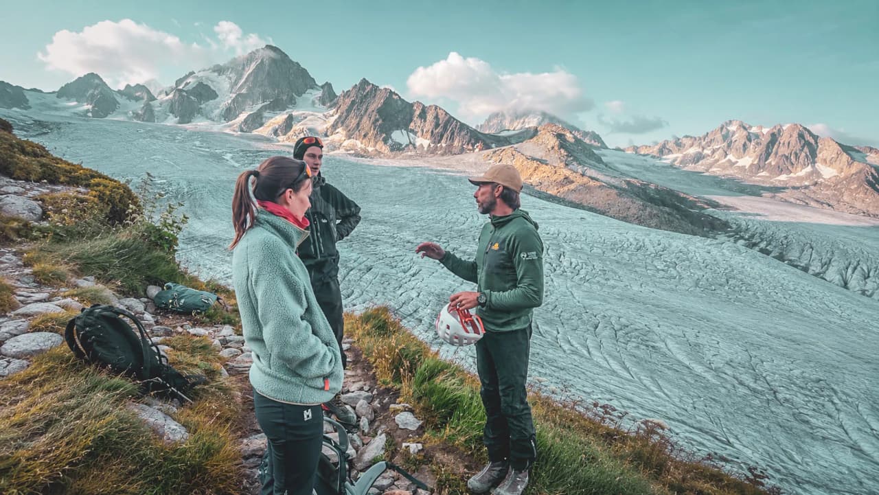 Un groupe d'alpinistes discute face à un glacier majestueux à Chamonix. Aventure assurée !