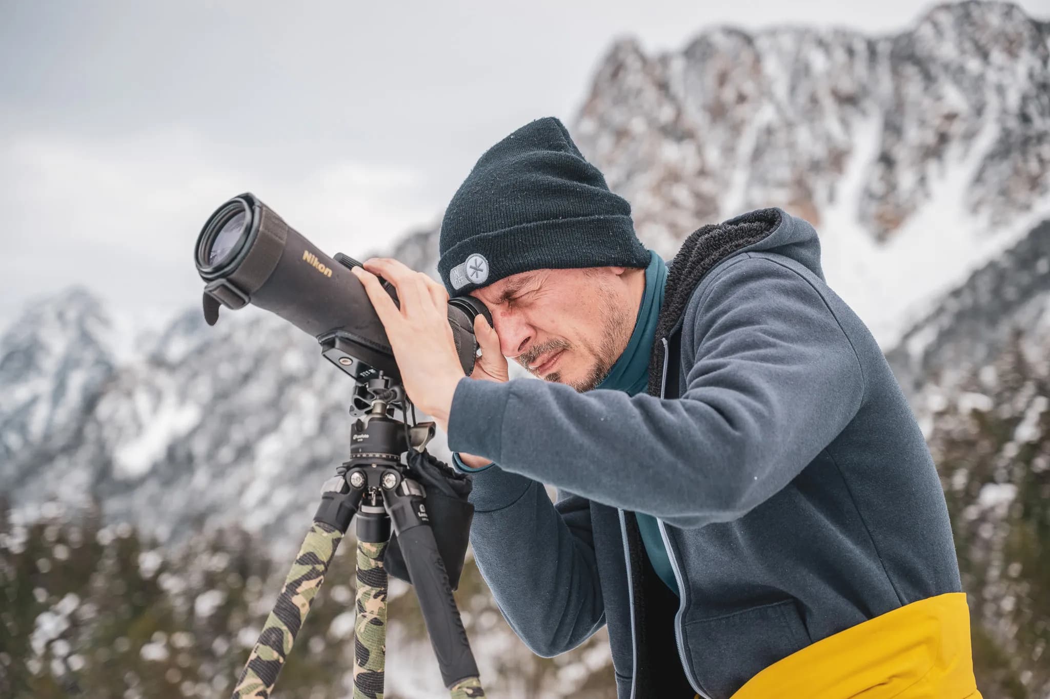 A photographer on a snow-covered mountain, capturing the wildlife of the Pyrenees. Adventure and nature.