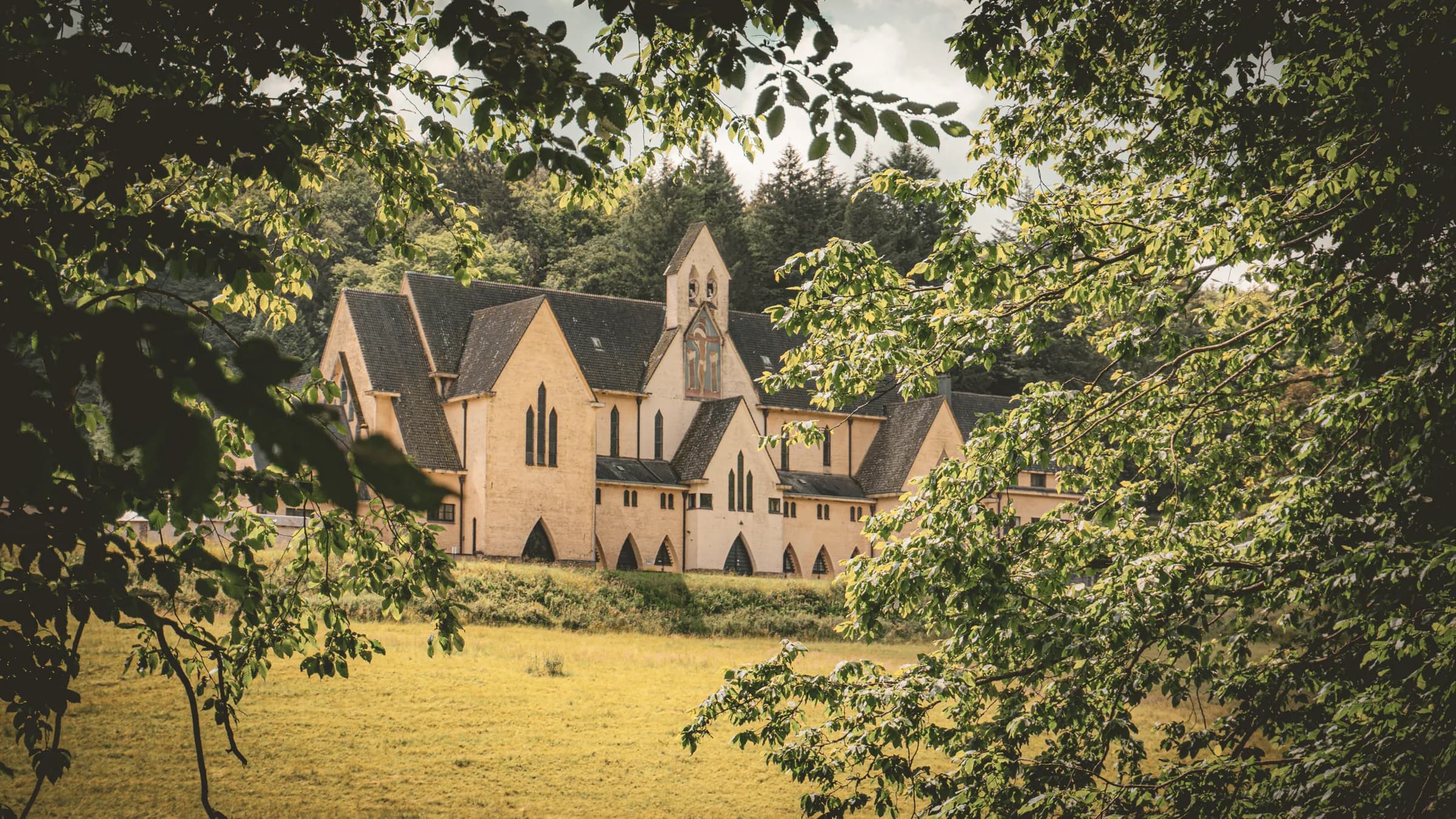 Een groen landschap met een pittoreske abdij in het hart van de Semoisvallei.