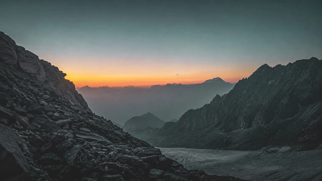 Coucher de soleil sur les montagnes majestueuses, promesse d'aventures en alpinisme.