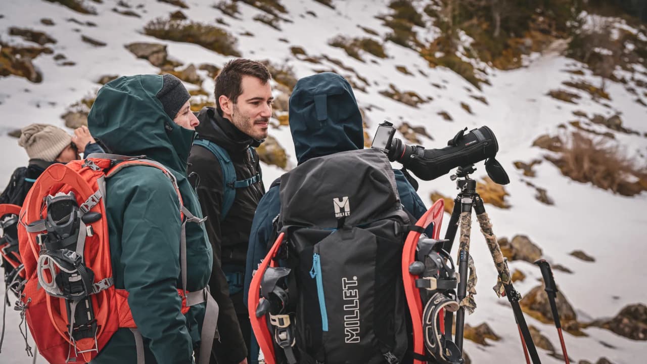 A group of snowshoe hikers admiring the snow-covered Pyrenees.
