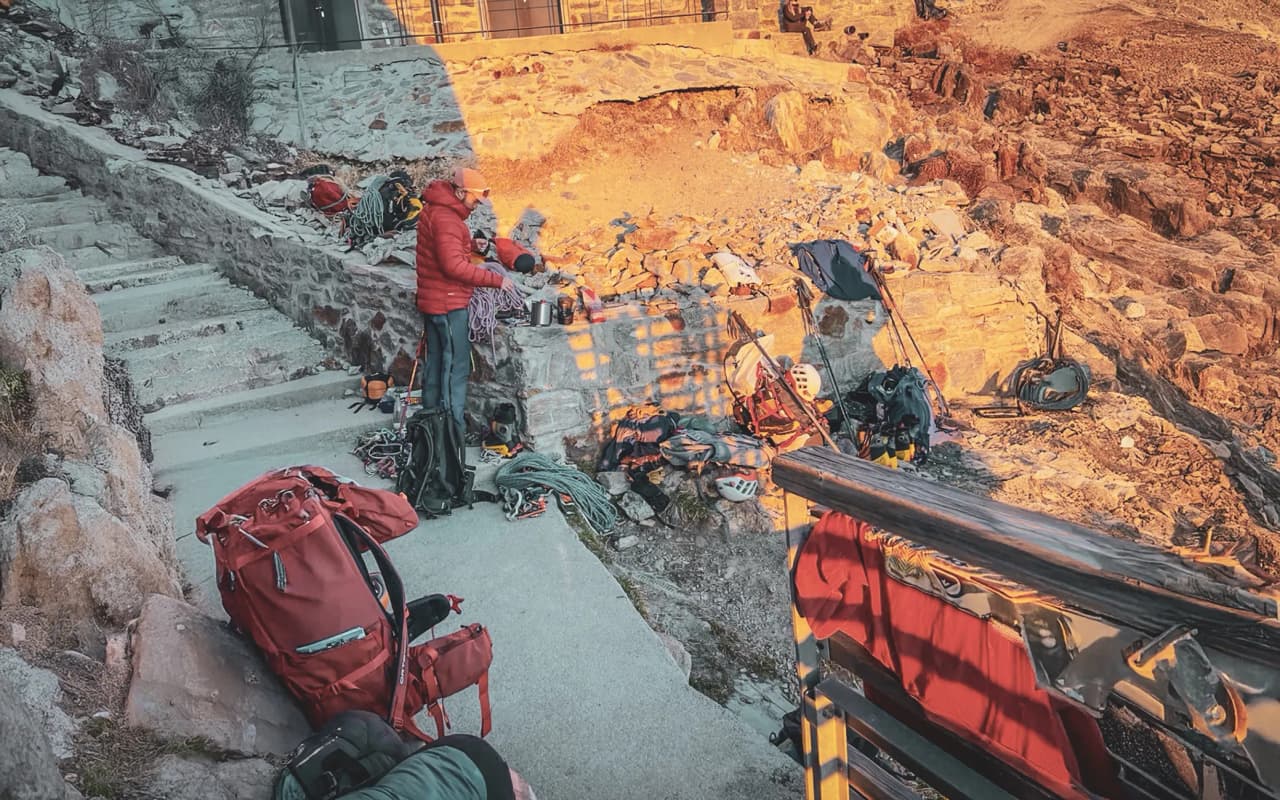 Un alpiniste prépare son équipement à Chamonix, entouré de montagnes majestueuses et de roches dorées.