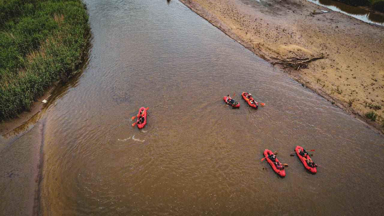 Een glimp van een packraft-expeditie op een Belgische rivier, omgeven door weelderig groen.