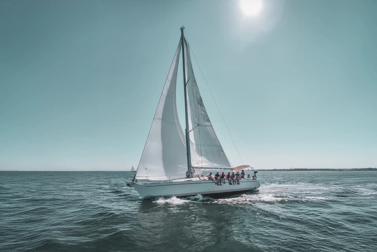 Voilier voguant sur des eaux turquoise ensoleillées, entouré de paysages marins idylliques.