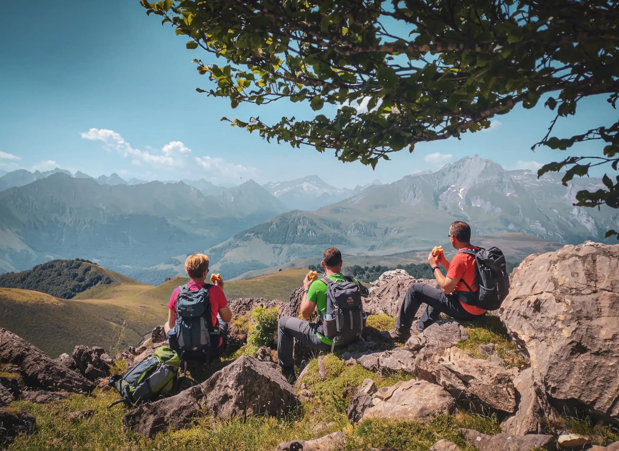 Trois randonneurs admirant les montagnes des Pyrénées, entourés de nature sauvage et paisible.
