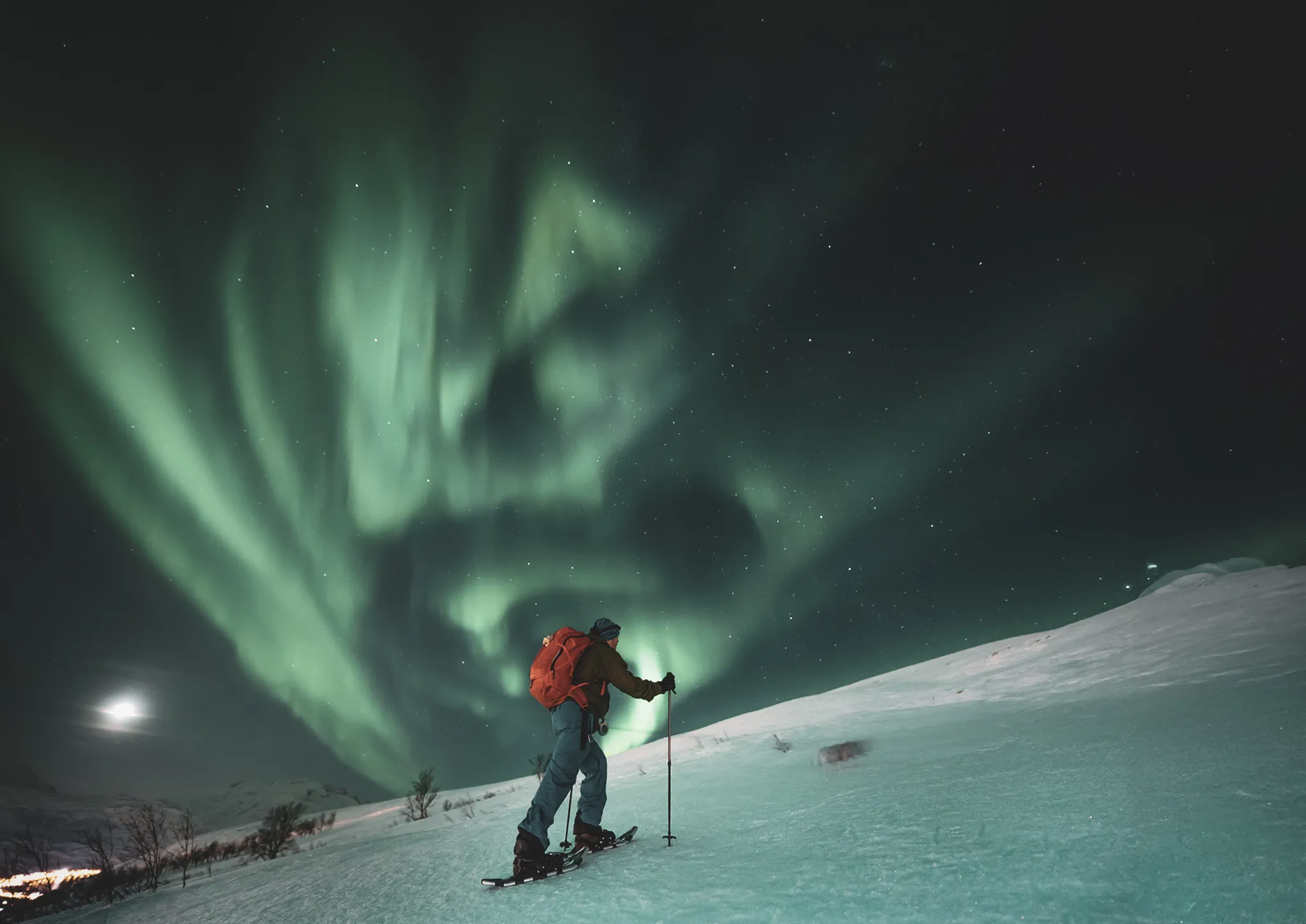 Homme en raquettes sous une aurore boréale, paysage glacé de Senja, Norvège. Magique !