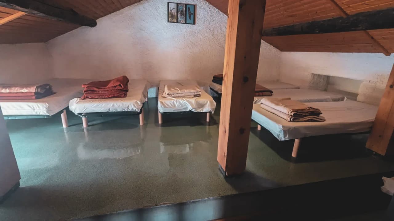 Room in an alpine Mountain hut, single beds ready for an overnight stay after a day's adventure in the mountains.