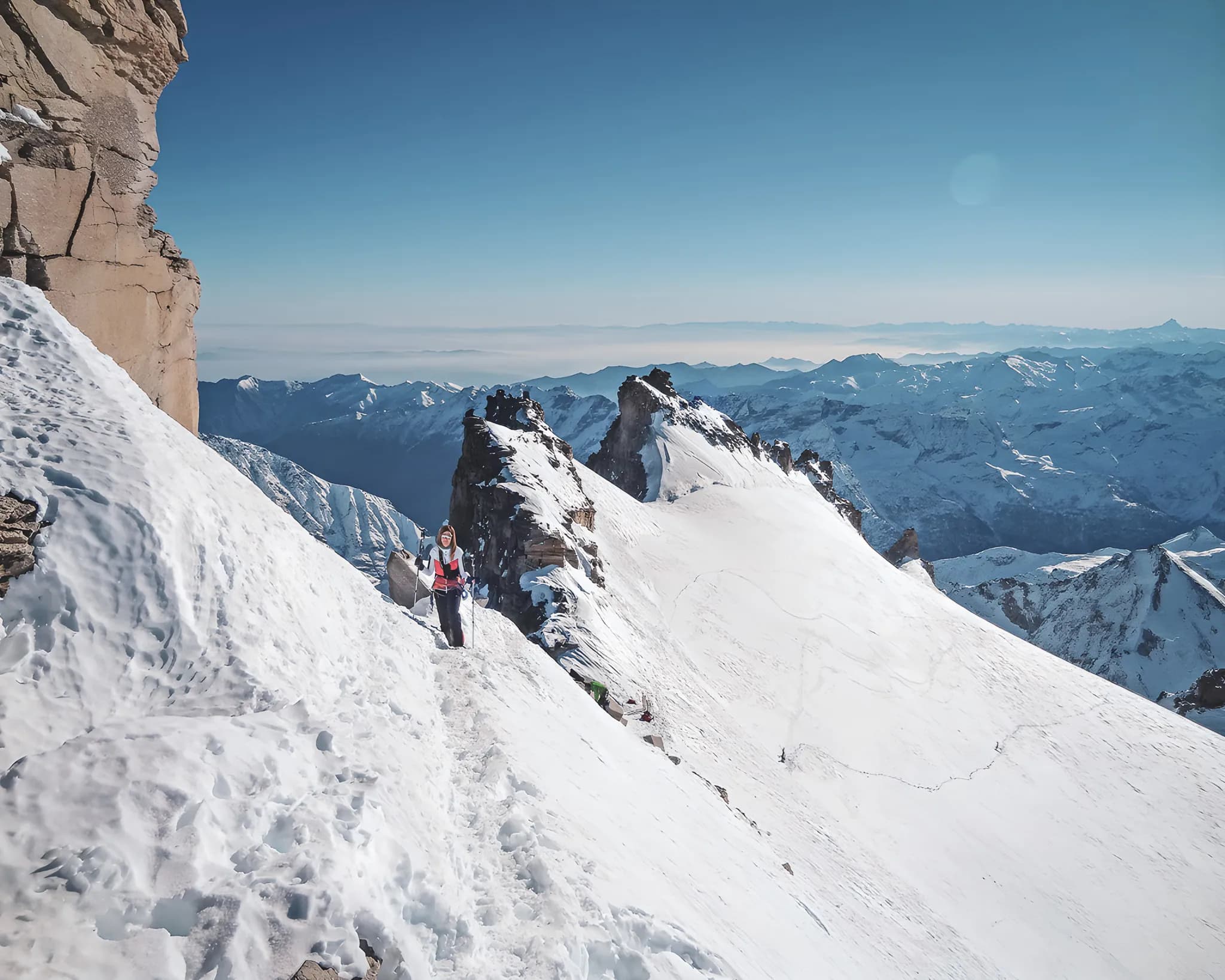 Cimes enneigées, skieur sur un sentier alpin, panorama époustouflant du Grand Paradis.