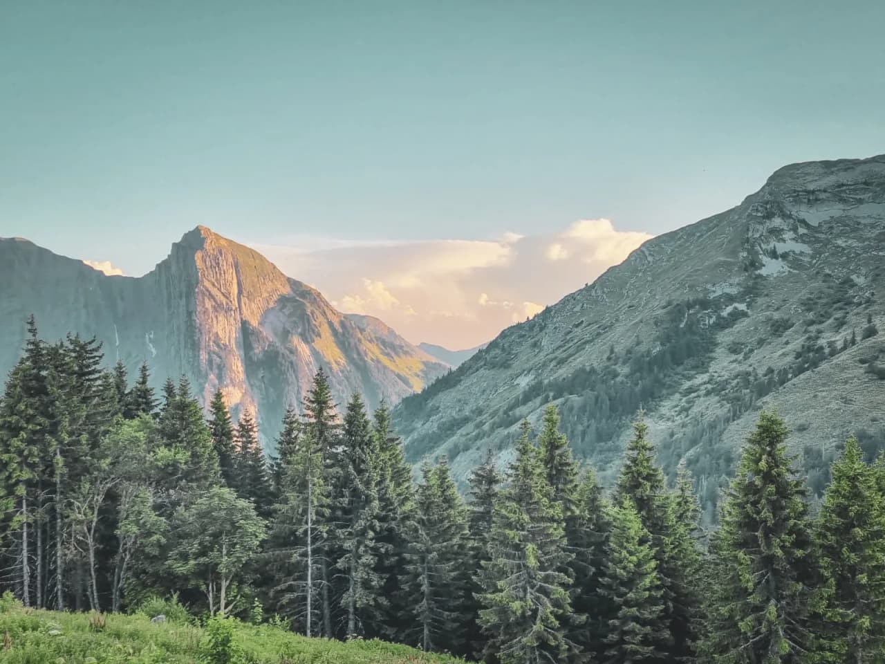The mountain landscape of the Hautes Bauges, with majestic peaks and lush green forests.