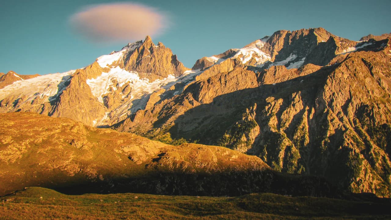Majestic panorama of the Écrins, facing the Meije, with glaciers and turquoise lakes under the sun.