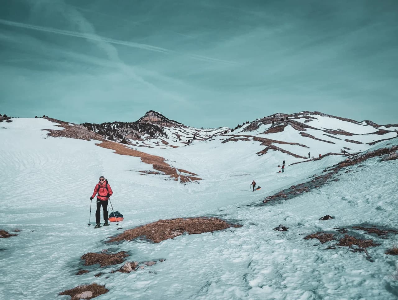 Snowshoe trekking through a snow-covered landscape, with majestic mountains on the horizon.