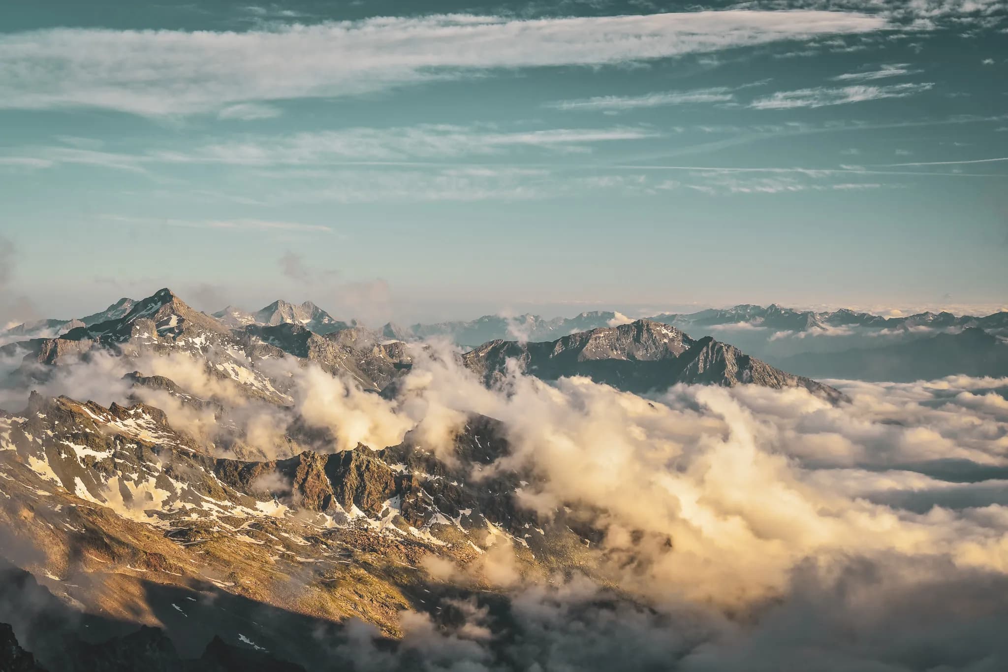 Spectacular view of the peaks of Mont Rose, shrouded in cloud and bathed in golden light.
