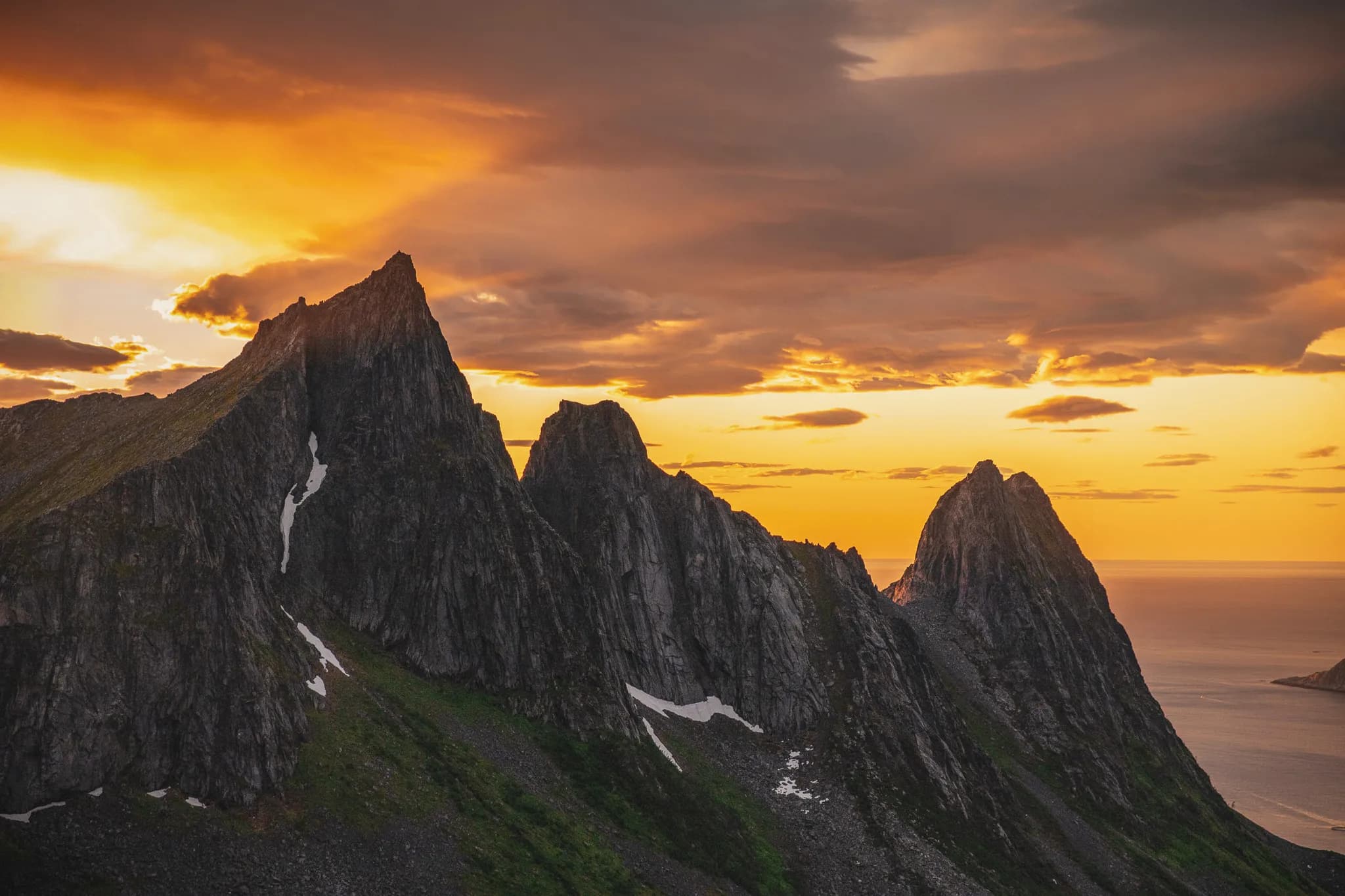 Majestic peaks under a blazing sky, the promise of adventure on the island of Senja.