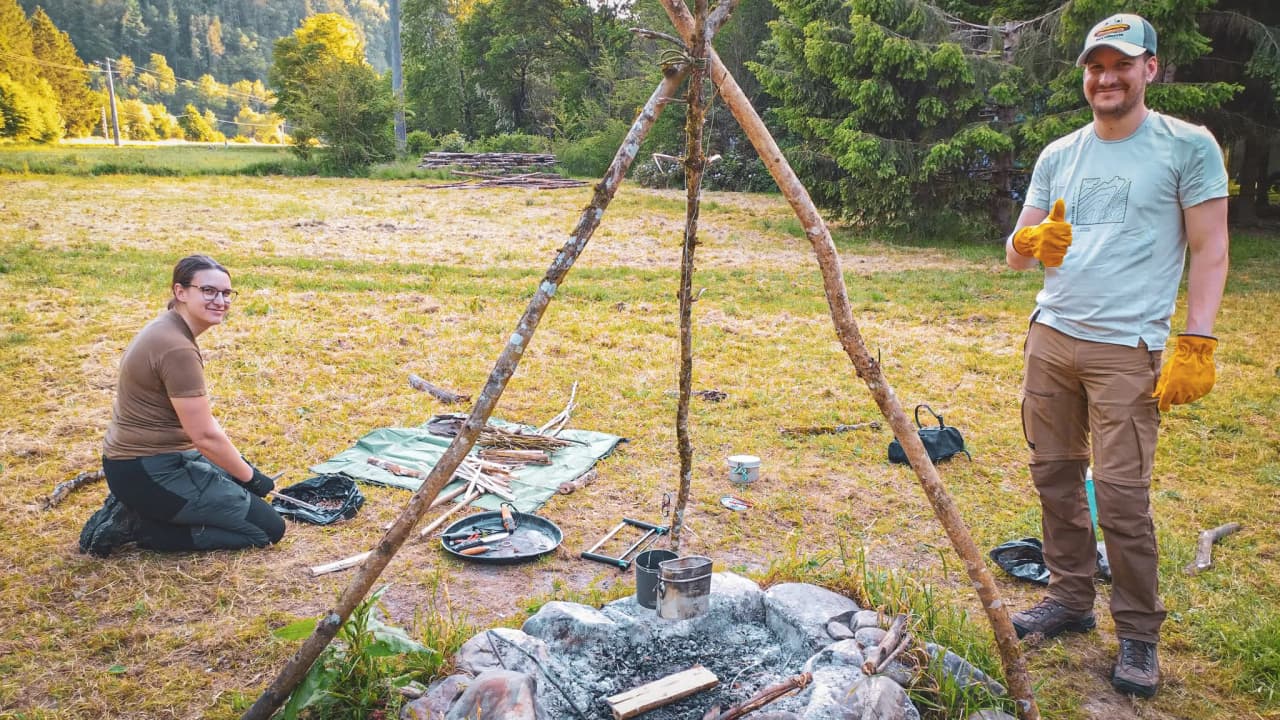 Participants d'un stage de survie dans la nature, préparant un feu au cœur de l'Ardenne belge.
