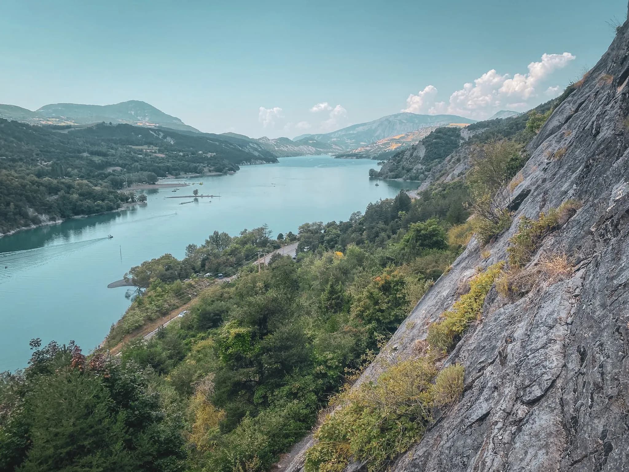 Panoramic views over the turquoise waters of the Ubaye, surrounded by lush green mountains.