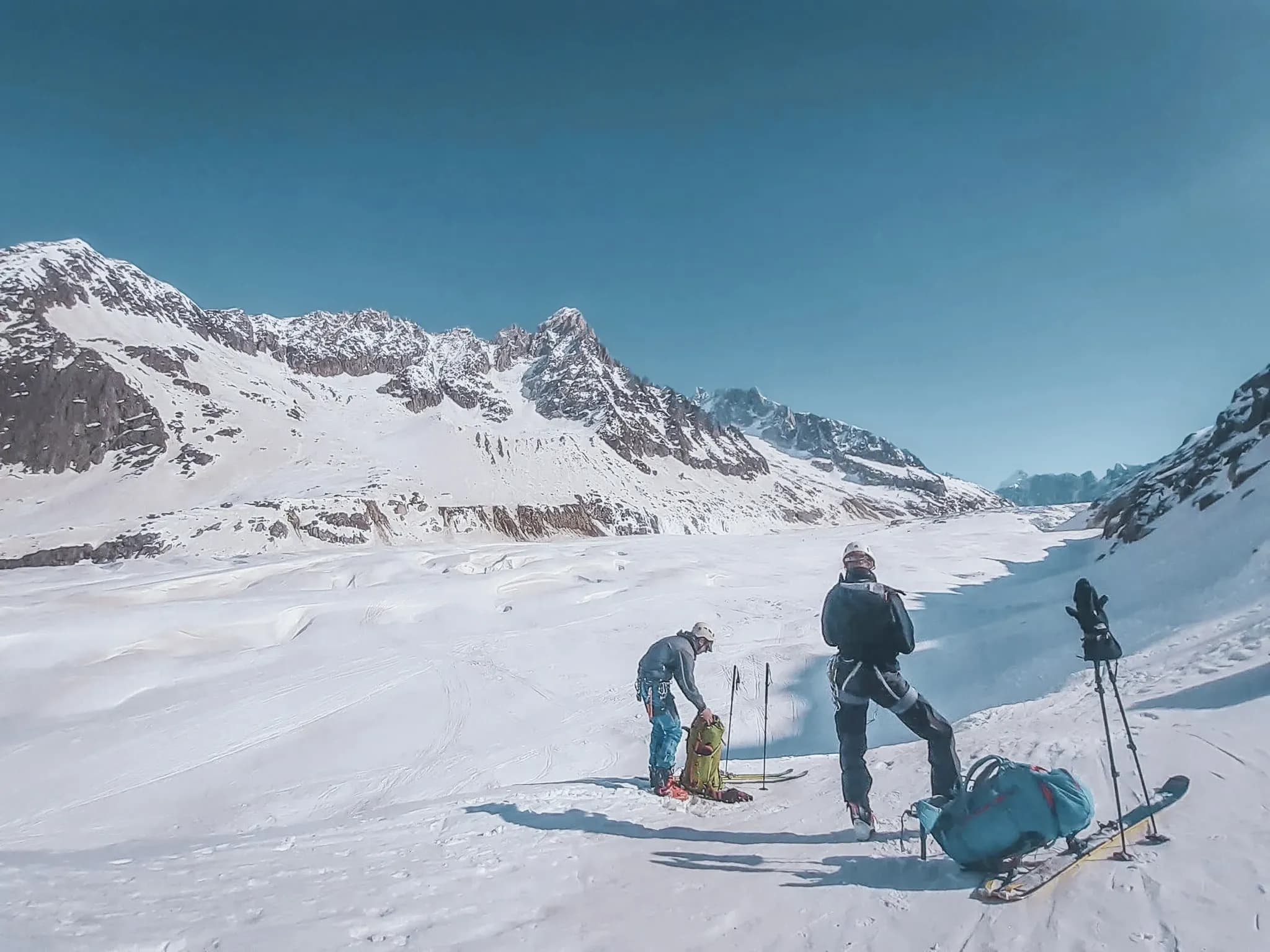 Groupe de skieurs devant des glaciers majestueux, ciel bleu, esprit d'aventure au Mont Blanc.