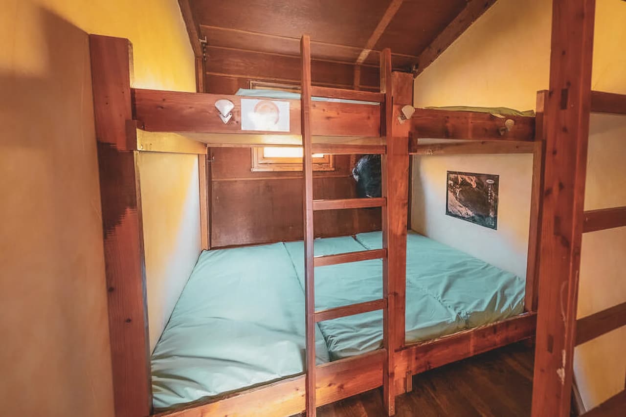 Chambre douillette en bois avec lits superposés, prête pour une aventure alpine.