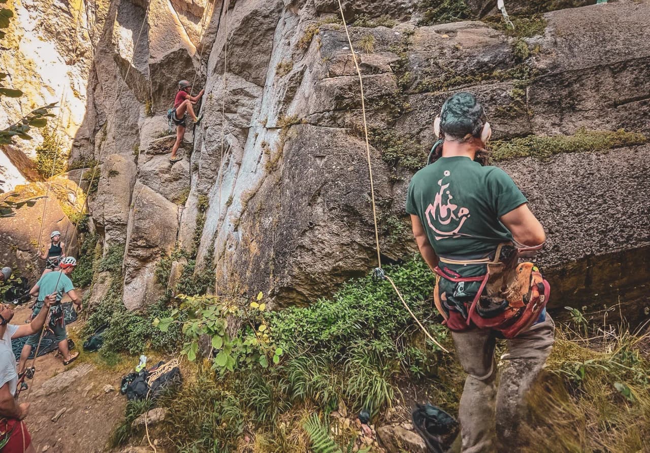 Groupe de grimpeurs dans un environnement rocheux, s'apprêtant à escalader une falaise.