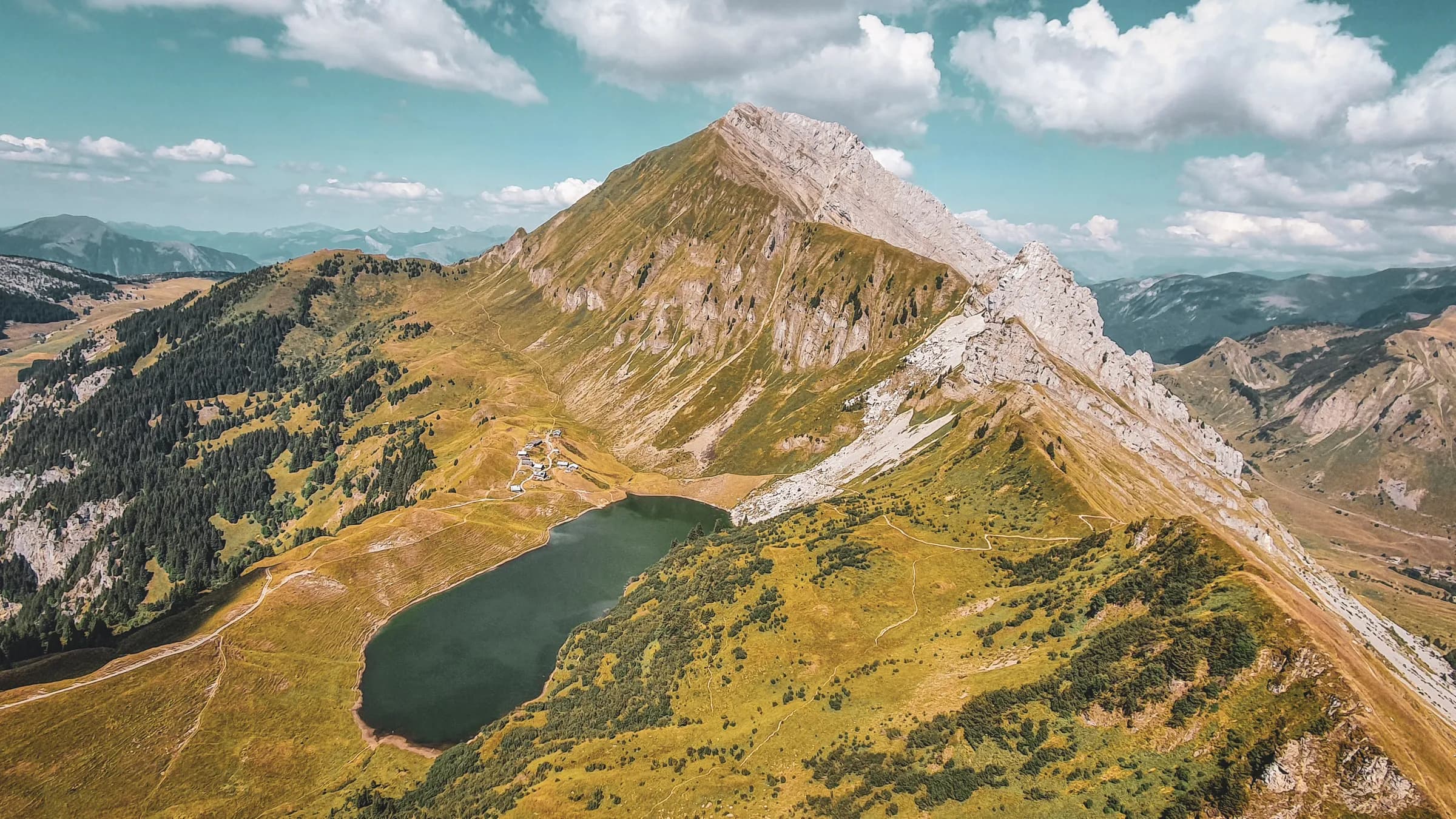 Magnificent alpine scenery with a peaceful lake surrounded by lush green mountains.