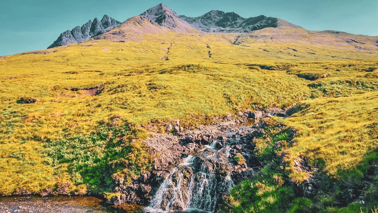 Adembenemende landschappen op het eiland Skye, tussen watervallen en groene bergen.