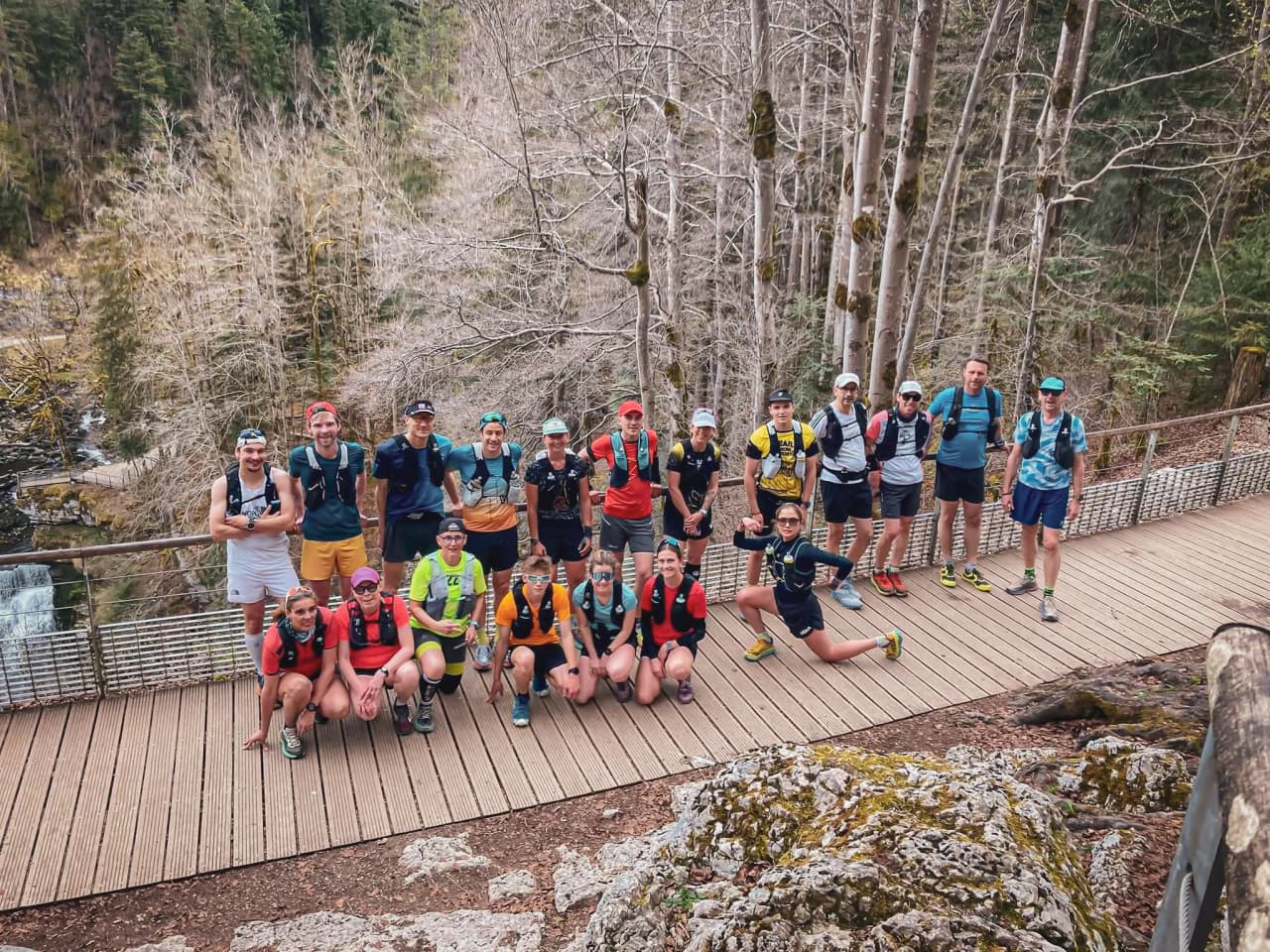 Een groep hardlopers in de buitenlucht, klaar voor een trailavontuur in de Jura, in een gezellige sfeer.