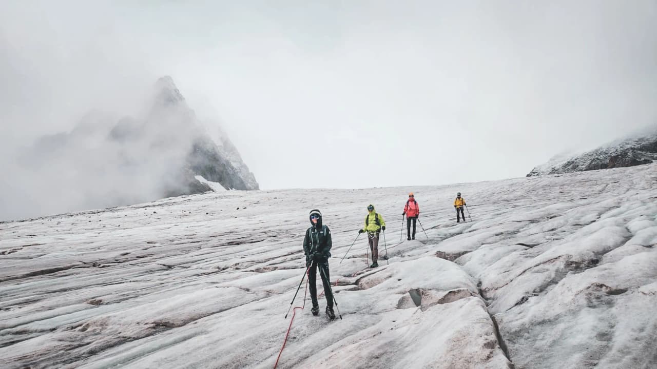 Des alpinistes sur un glacier aux Écrins, prêts à gravir des sommets majestueux.