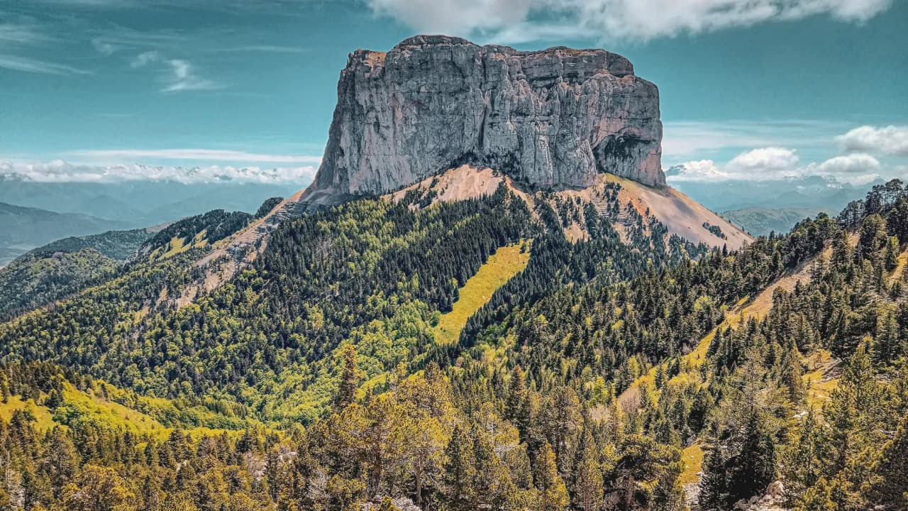 Majestic Mont Aiguille, surrounded by lush green forests and enchanting landscapes.