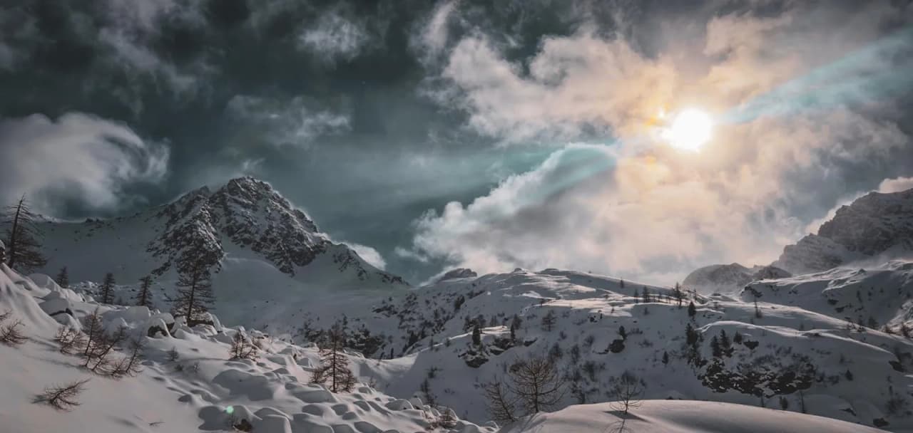Paysage alpin enchanteur, montagnes enneigées sous un ciel nuageux et un soleil radieux.
