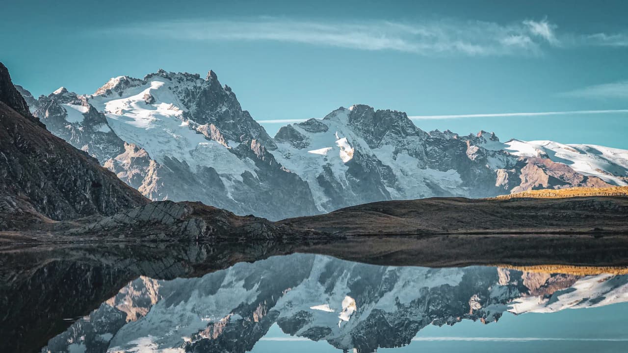 Reflets majestueux des montagnes alpines sous un ciel serein, invitant à l'évasion.
